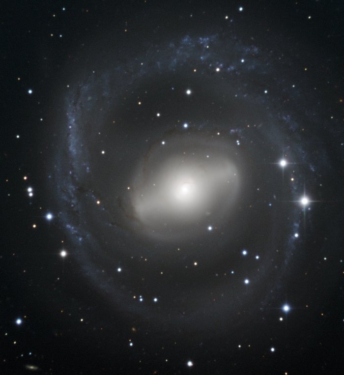 Barred spiral galaxy swirls in the night sky