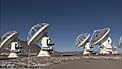 Pan over ALMA array of antennas on Chajnantor as they move in unison