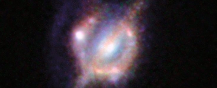 Verschmelzende Galaxien im frühen Universum unter einer kosmischen Lupe