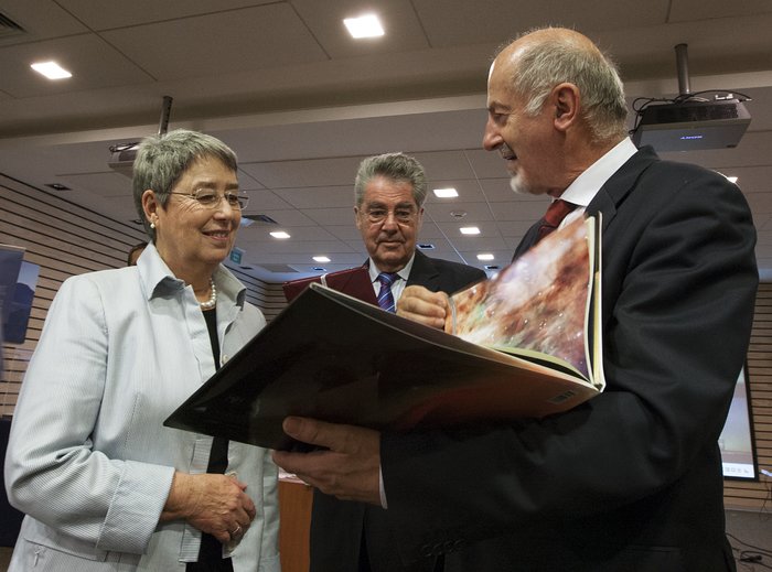 La foto muestra al Presidente Fischer y su esposa Margit Fischer mirando el libro 