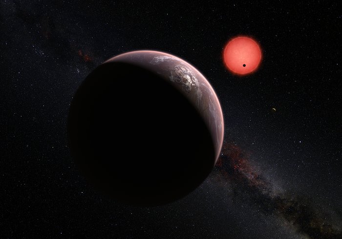 Představa mimořádně chladného trpaslíka TRAPPIST-1 a jeho tří planet
