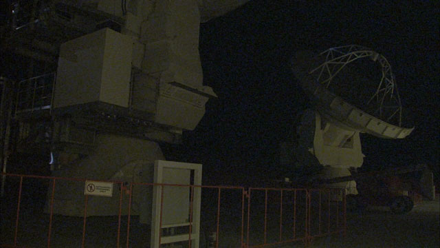 An ALMA antenna moves in the night
